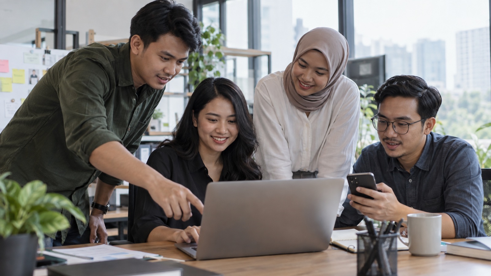 Tim marketing berdiskusi di depan laptop dan smartphone